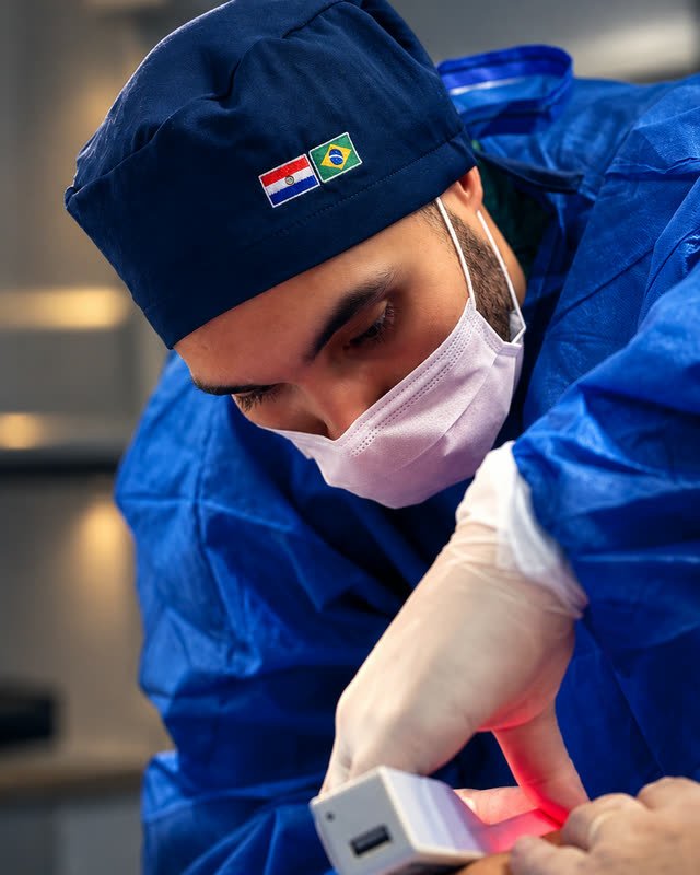 Dr. Jonatas Carvalho aplicando el tratamiento, con el gorro de Paraguay y Brasil